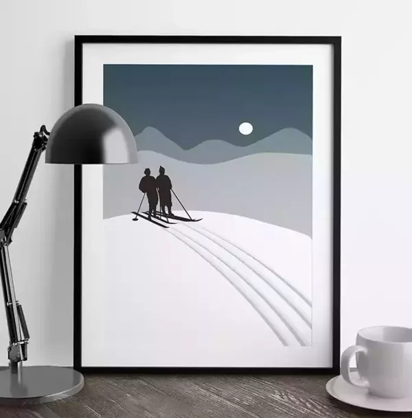 Plakat med skiløpere i vinterlandskap satt i et kosleig miljø med bordlampe og kaffekopp. fra Poppydesign.